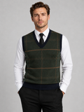 Front view of a man wearing a green V-neck sweater vest with a diamond cable knit pattern and warm pullover design