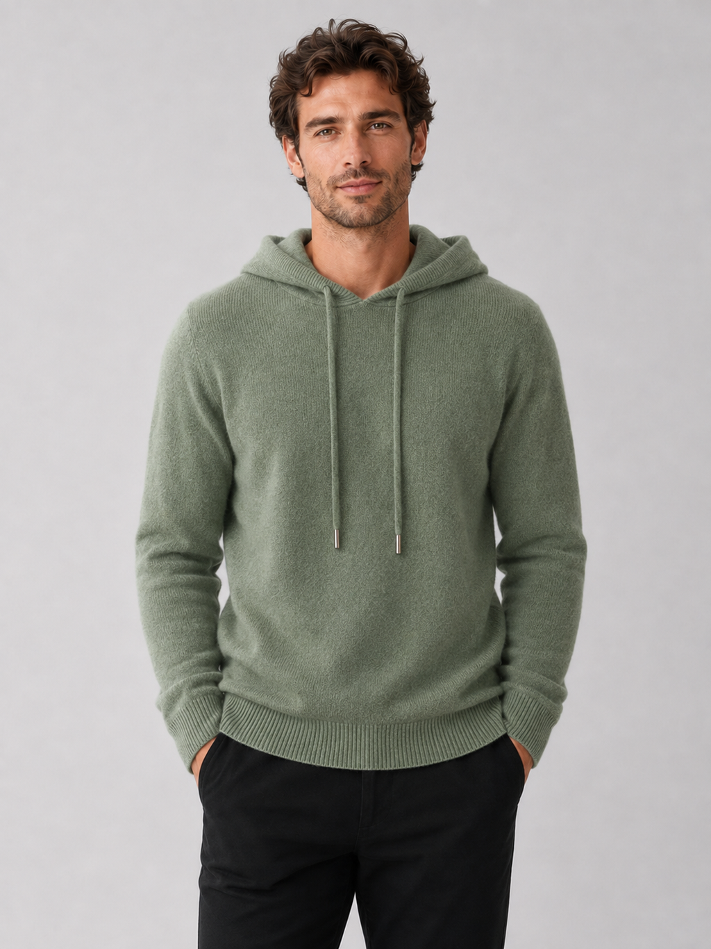 Front view of a man wearing a green wool hoodie sweater with a soft knit design, attached hood, and long sleeves