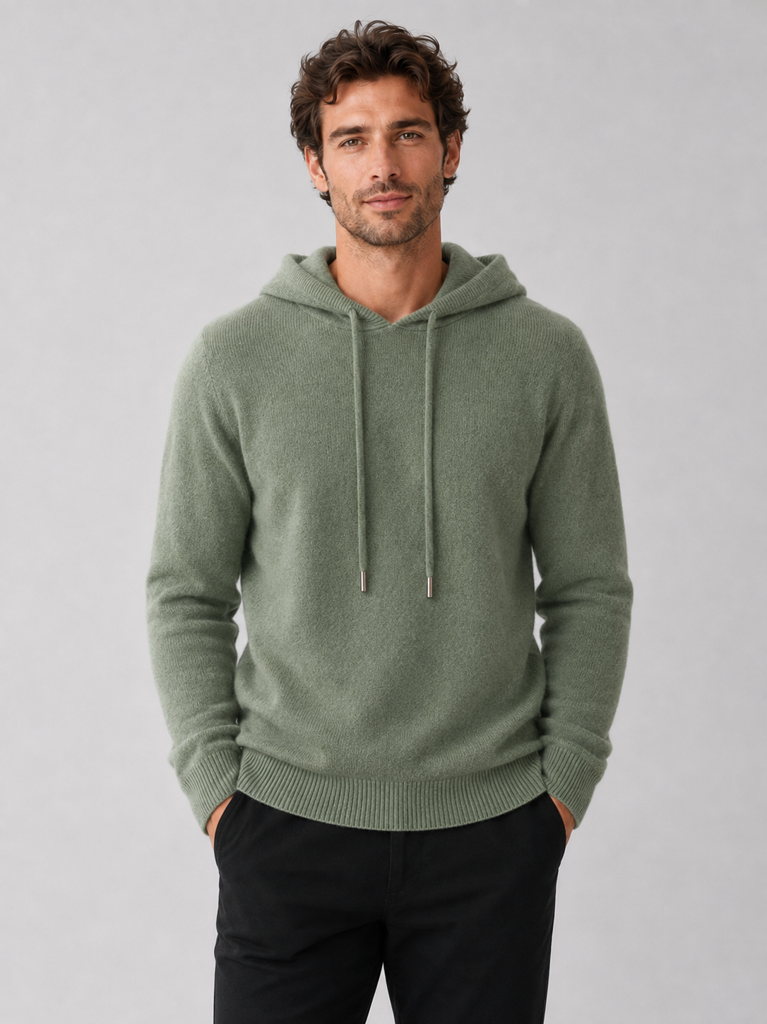 Front view of a man wearing a green wool hoodie sweater with a soft knit design, attached hood, and long sleeves
