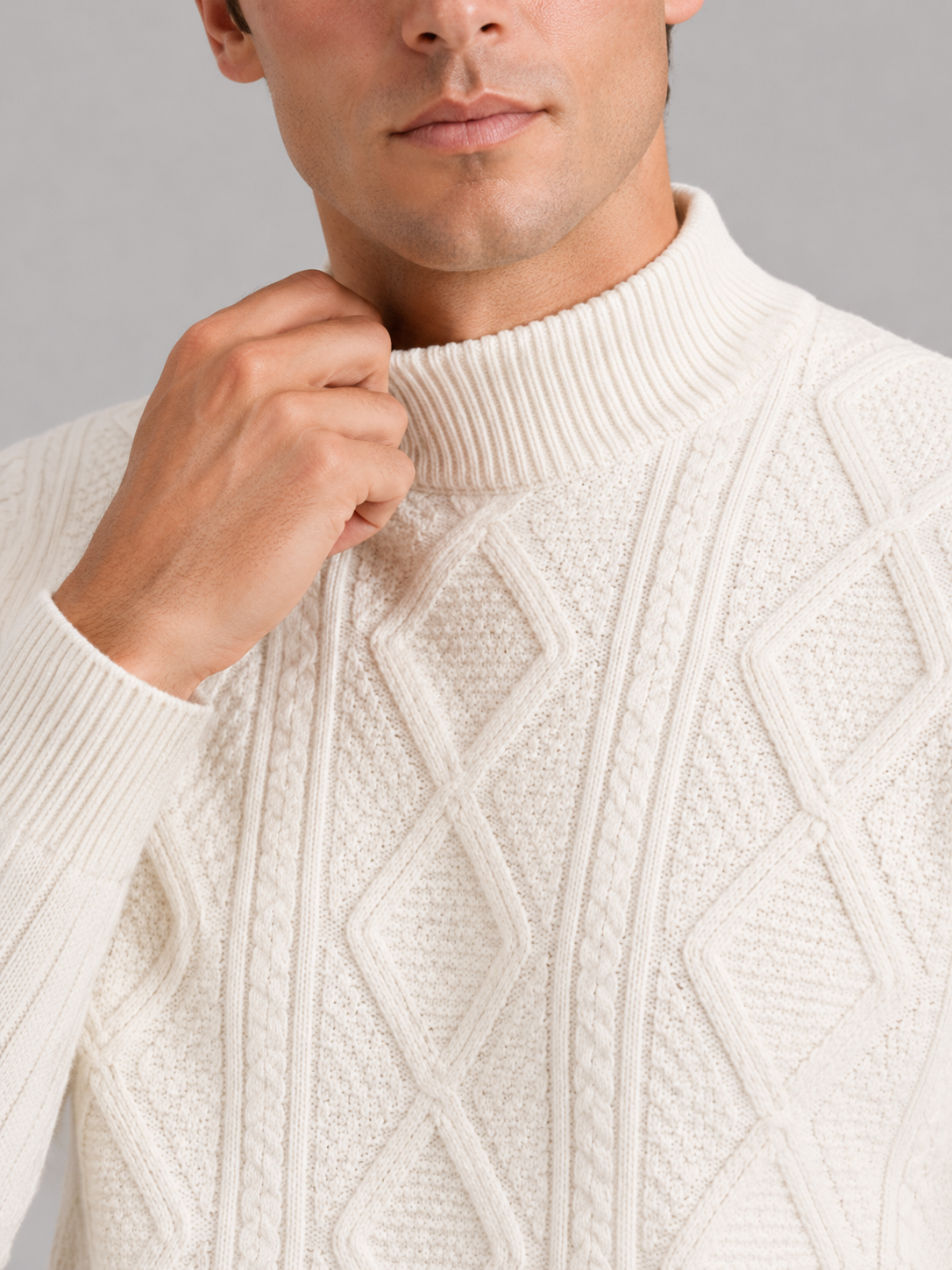 Close up of ivory mock neck sweater showing jacquard twist cable knit texture and soft warm fabric