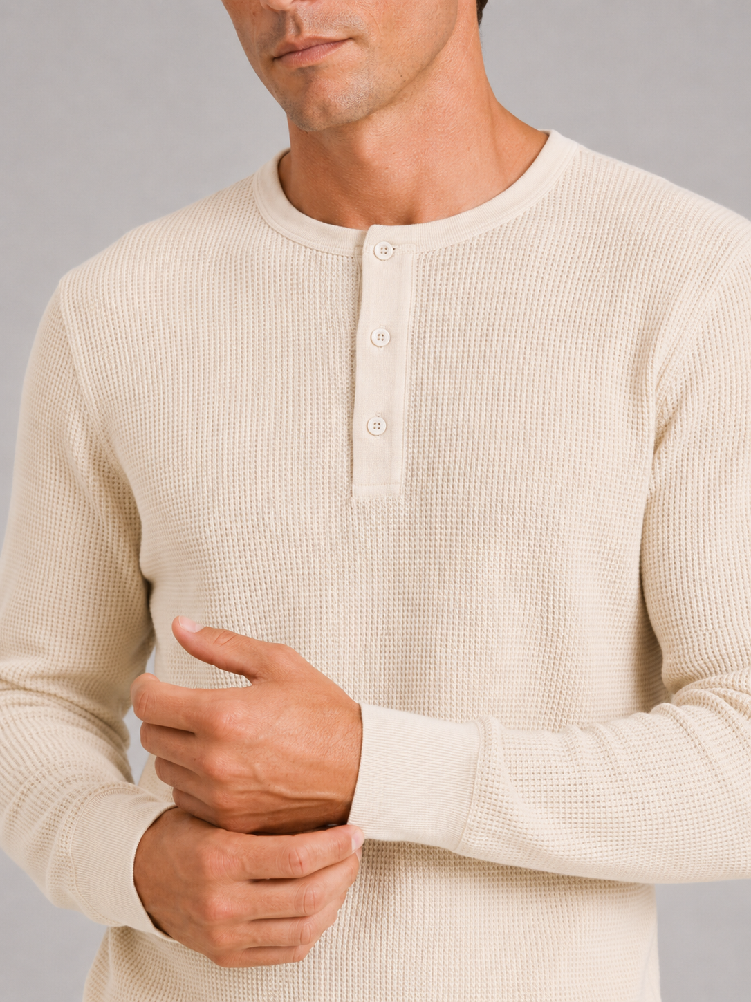 Close up of ivory waffle knit henley showing breathable textured fabric and button detail