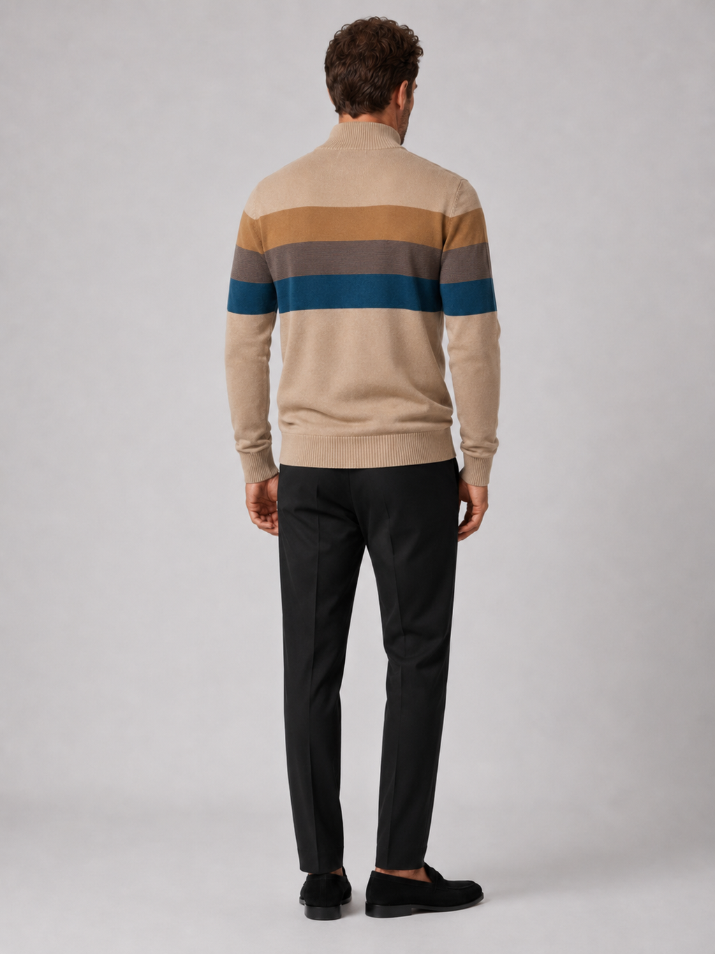 Back view of a man wearing a khaki cotton quarter zip sweater showing the patchwork design and relaxed fit