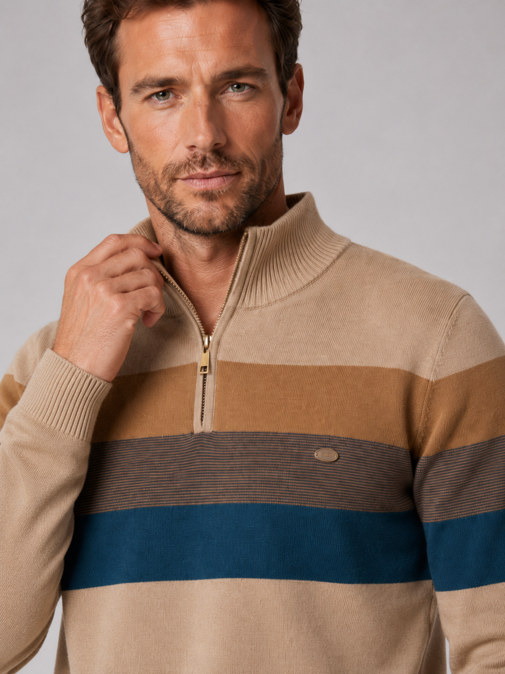 Close-up of a khaki patchwork quarter zip sweater showing the cotton knit texture, mock neck, zipper, and stitching
