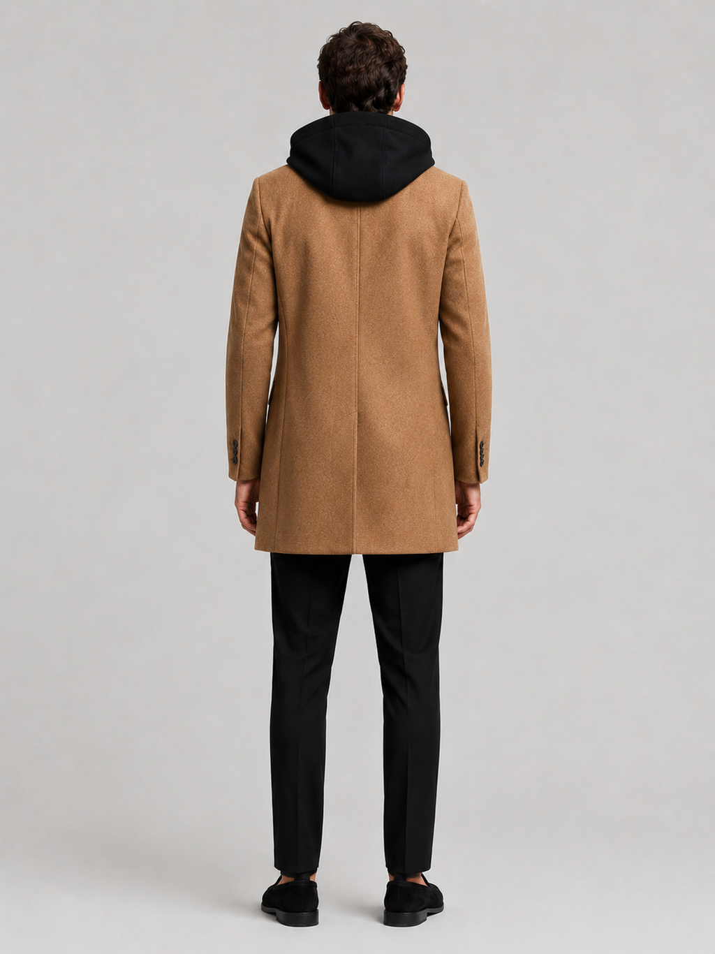 Backside photo of a man wearing a khaki wool hooded trench coat, showing the hood, back seam, coat length, and tailored winter fit