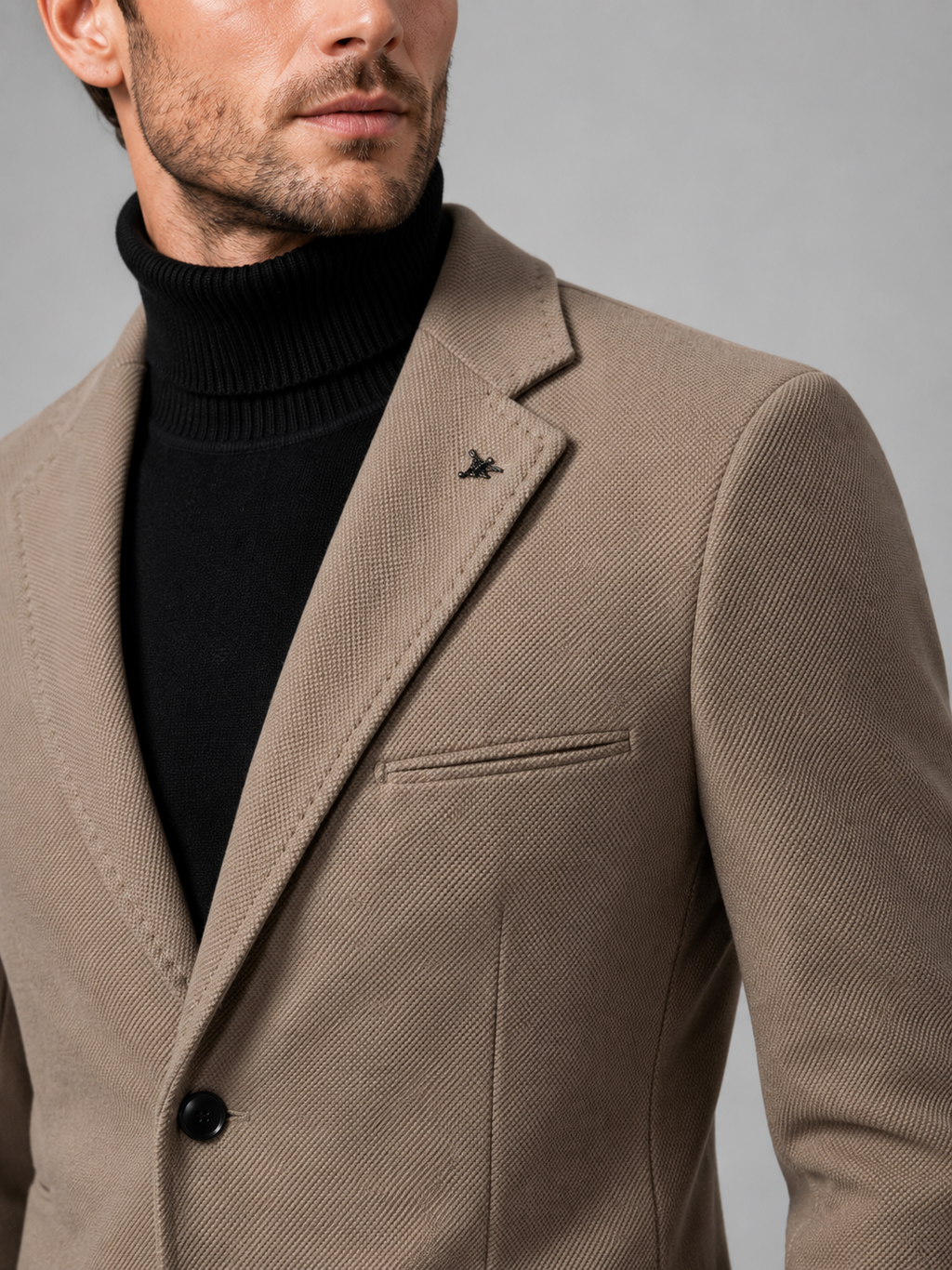Close up of khaki blazer showing tailored construction, notch lapel, and single breasted button detail