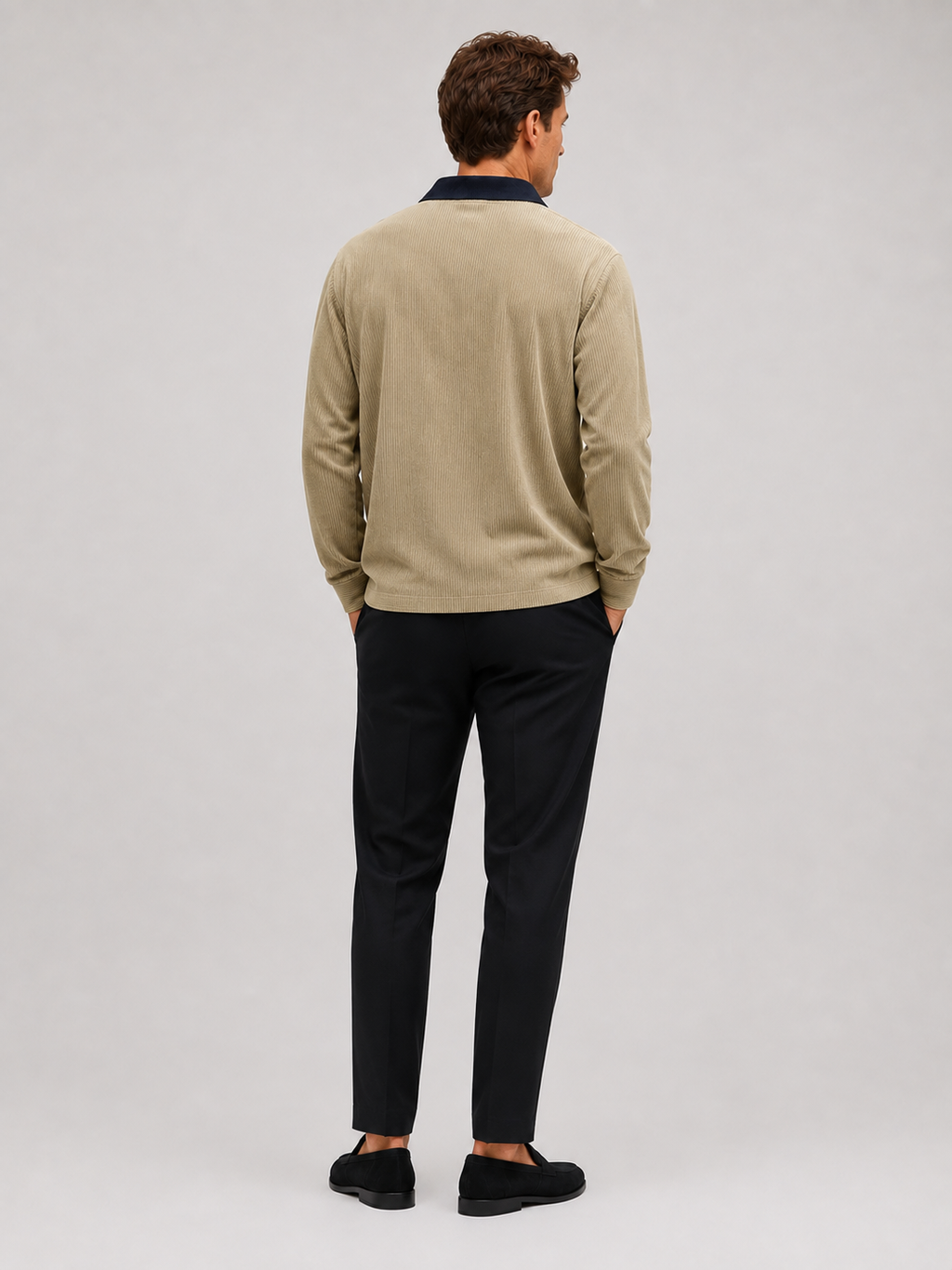 Back view of a man wearing a khaki corduroy polo shirt showing the long sleeves, relaxed fit, and soft textured fabric