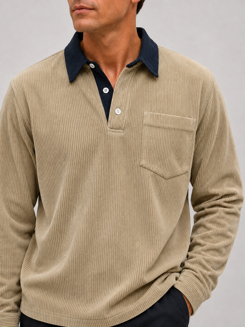 Close-up of a khaki corduroy polo shirt showing the textured polyester fabric, contrast turn-down collar, button placket, cuffs, and stitching