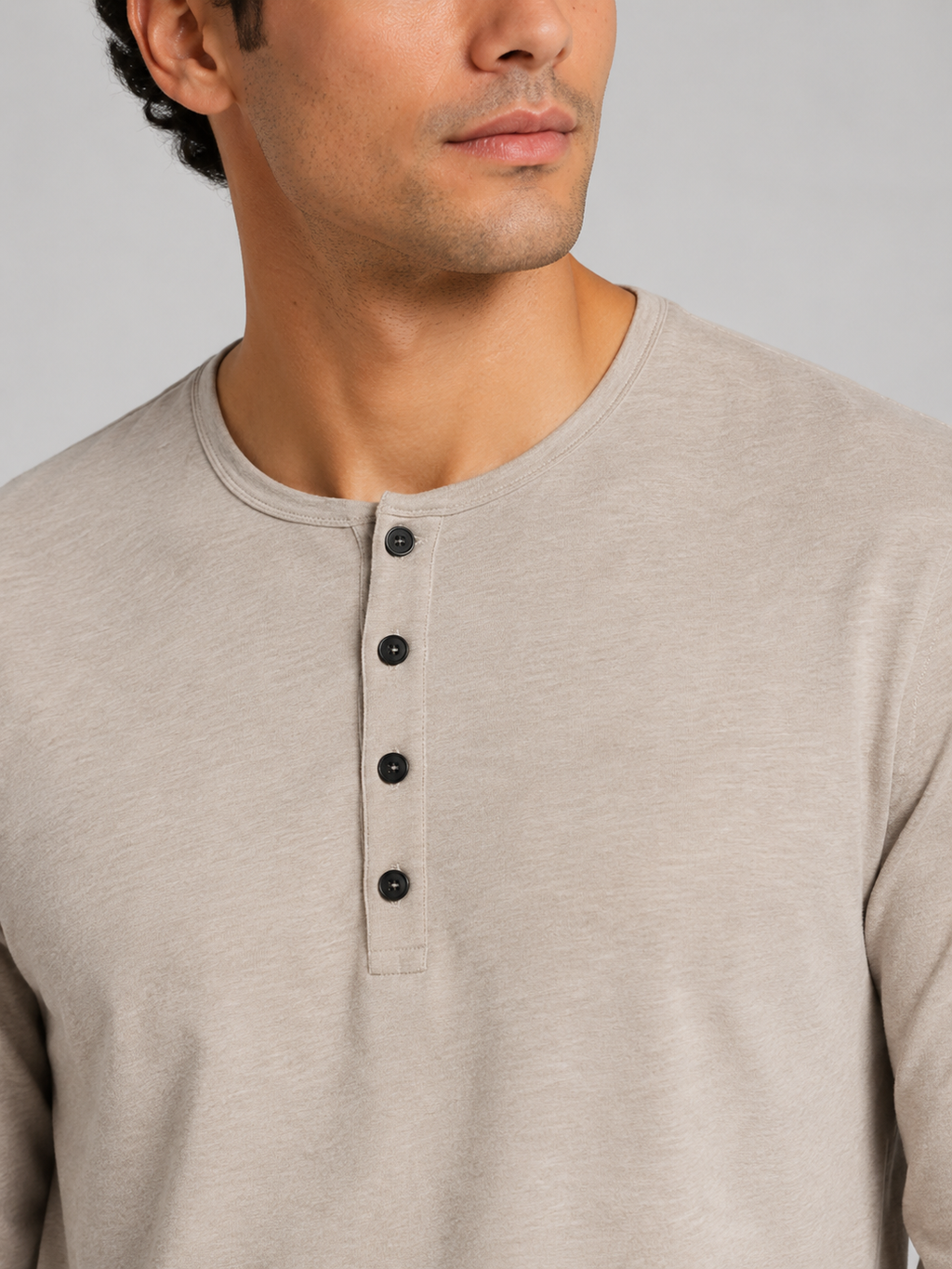 Close up of khaki henley shirt fabric showing soft smooth breathable texture and button detail