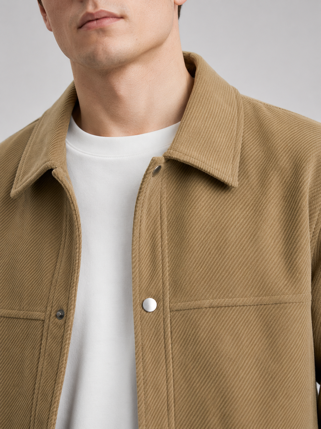 Close up of khaki corduroy jacket showing soft ribbed texture, classic lapel, and button front detail