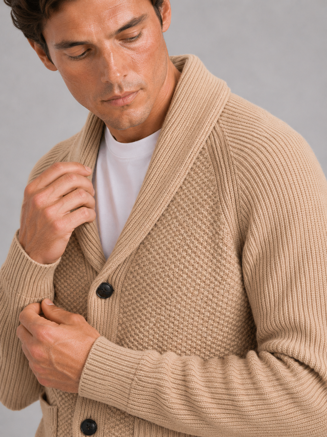 Close up of khaki knit cardigan showing soft textured fabric and front pocket detail