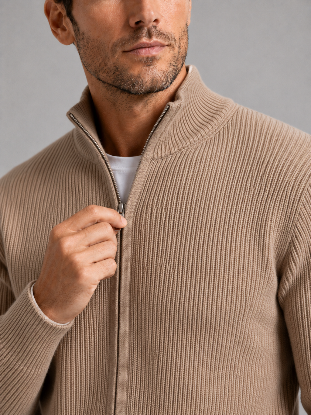Close-up of a khaki ribbed knit cardigan showing the textured knit fabric, stand collar, full zipper, ribbed cuffs, hem, and stitching details