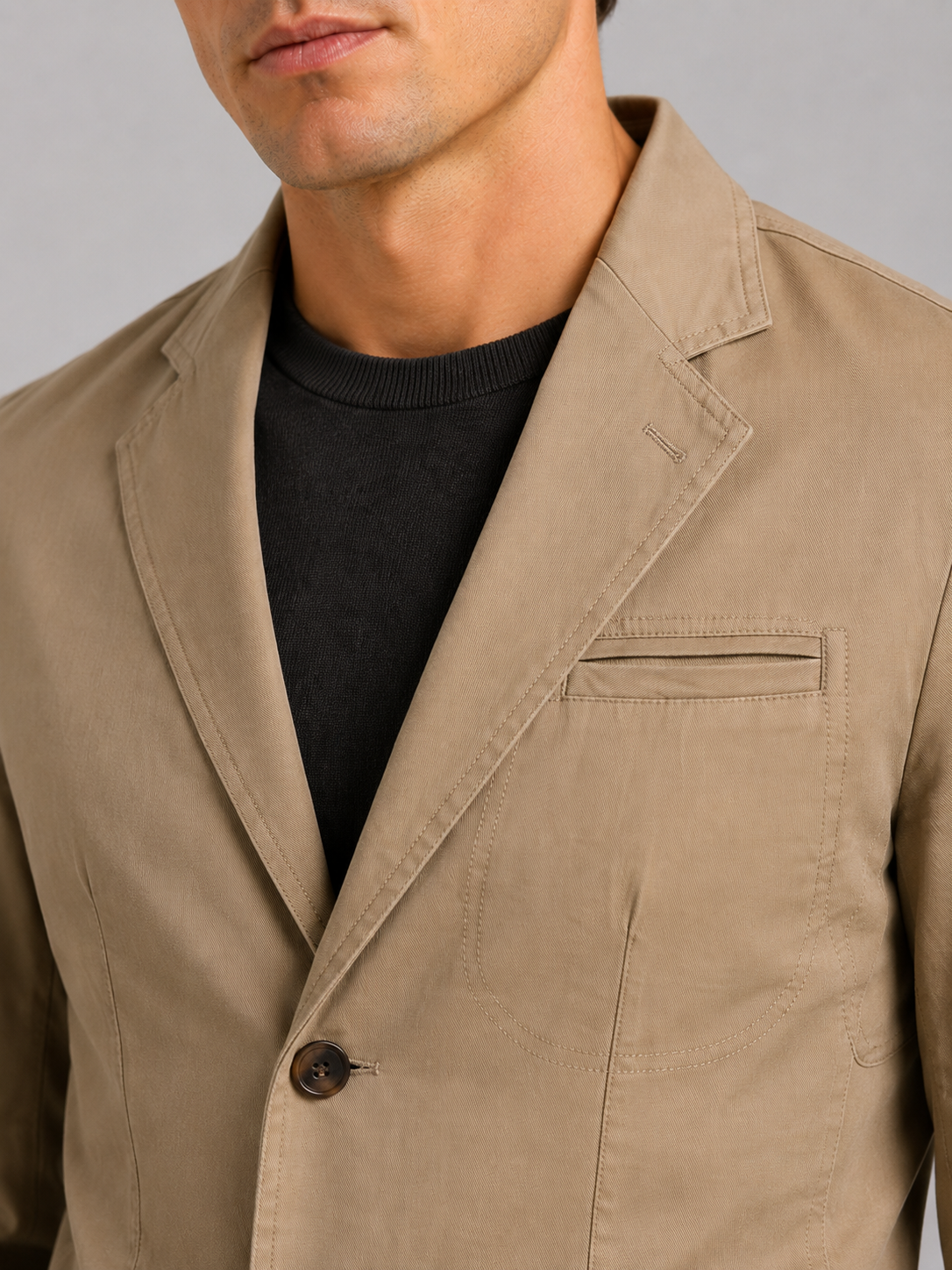 Close up of khaki washed cotton blazer jacket showing soft texture and tailored lapel detail