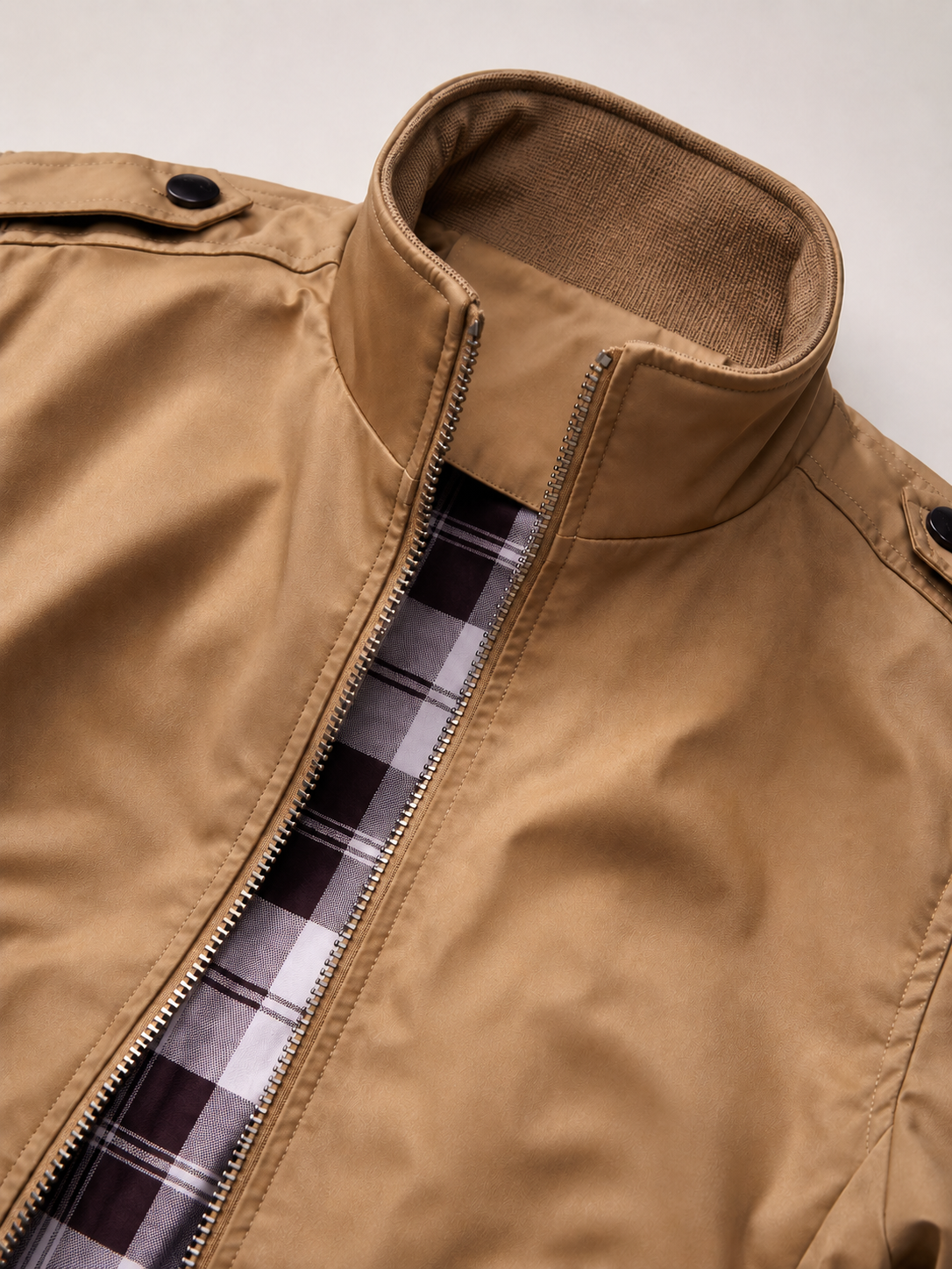 Close up of khaki trench jacket showing smooth lightweight fabric and stand collar detail