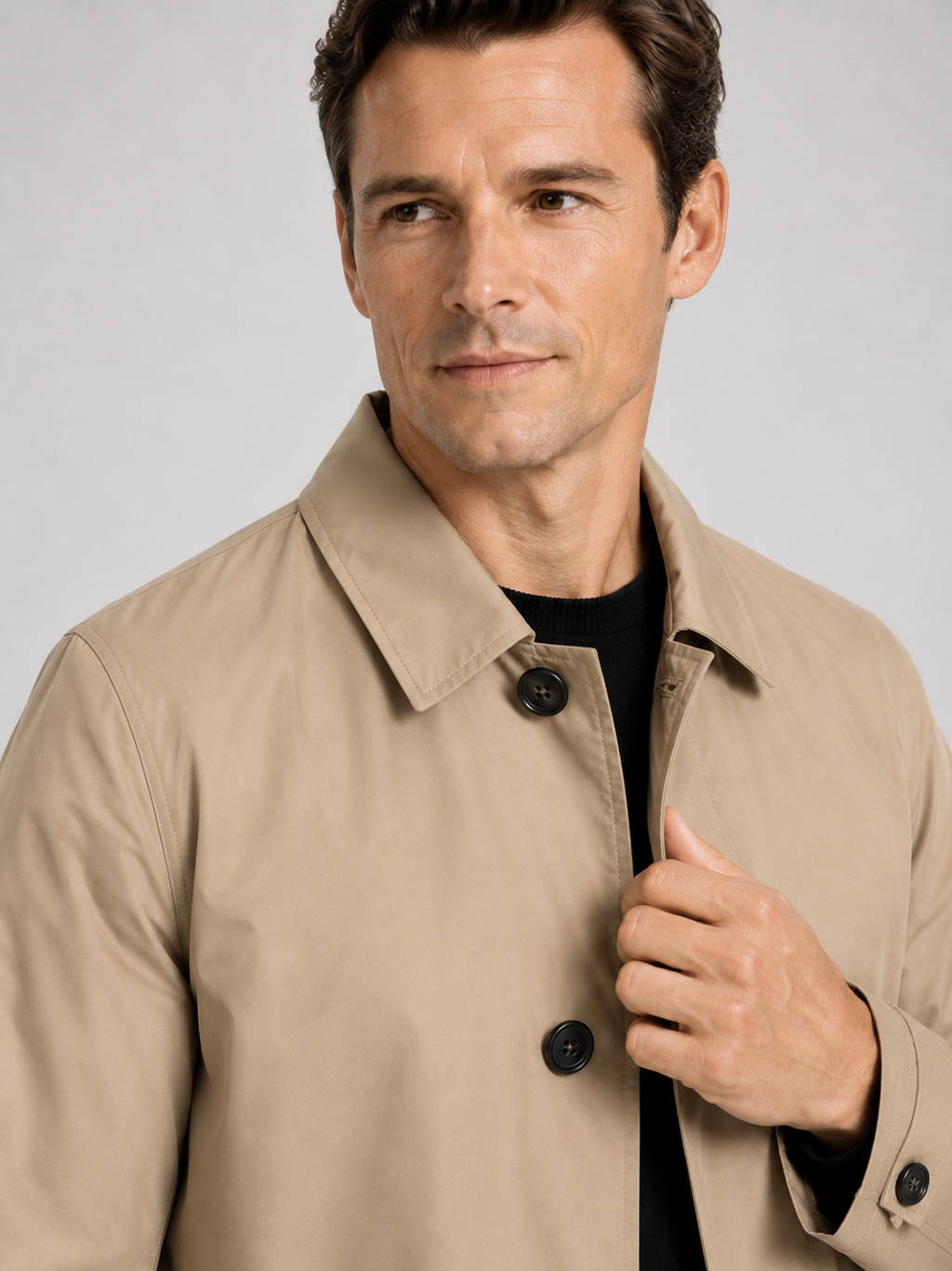 Close up of khaki trench coat showing structured lapel, button up front, and premium fabric detail