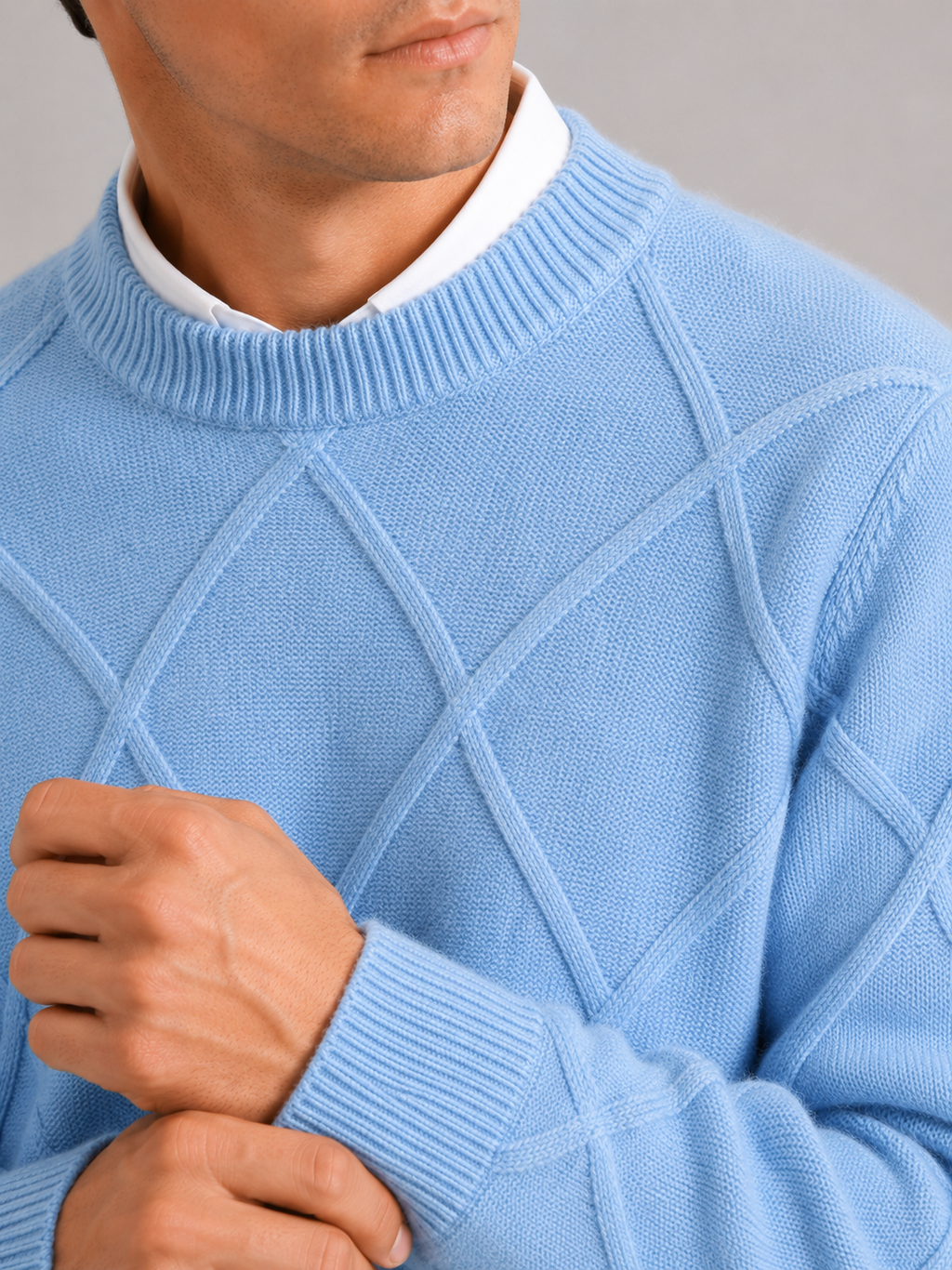 Close up of light blue cable knit sweater showing soft fleece texture and thick woven detail