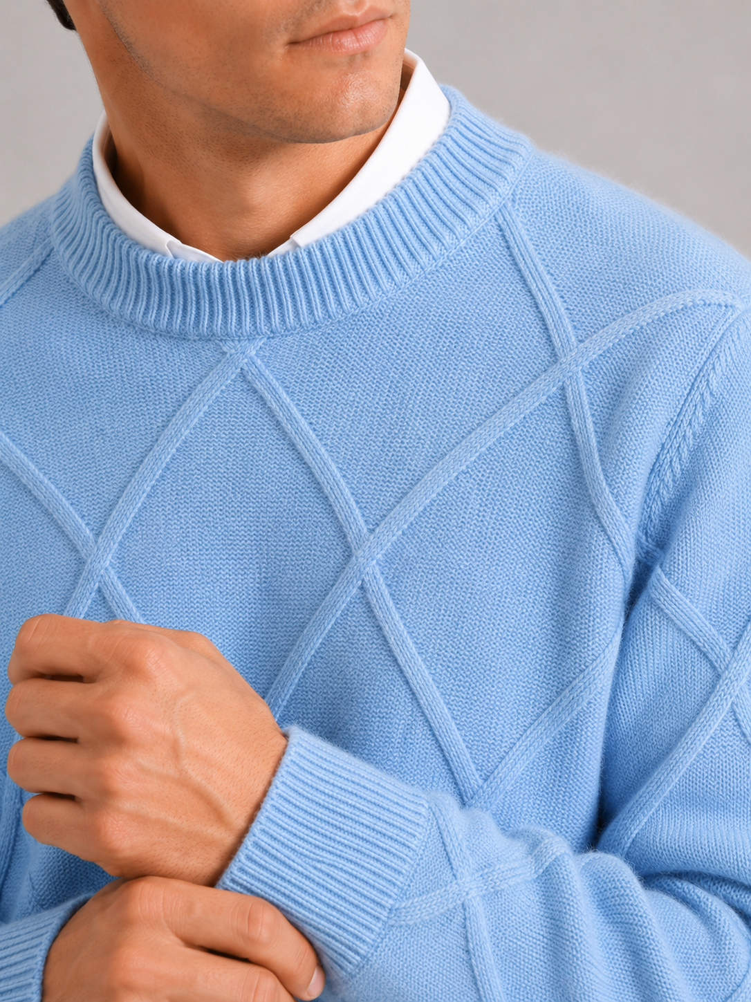 Close up of light blue cable knit sweater showing soft fleece texture and thick woven detail