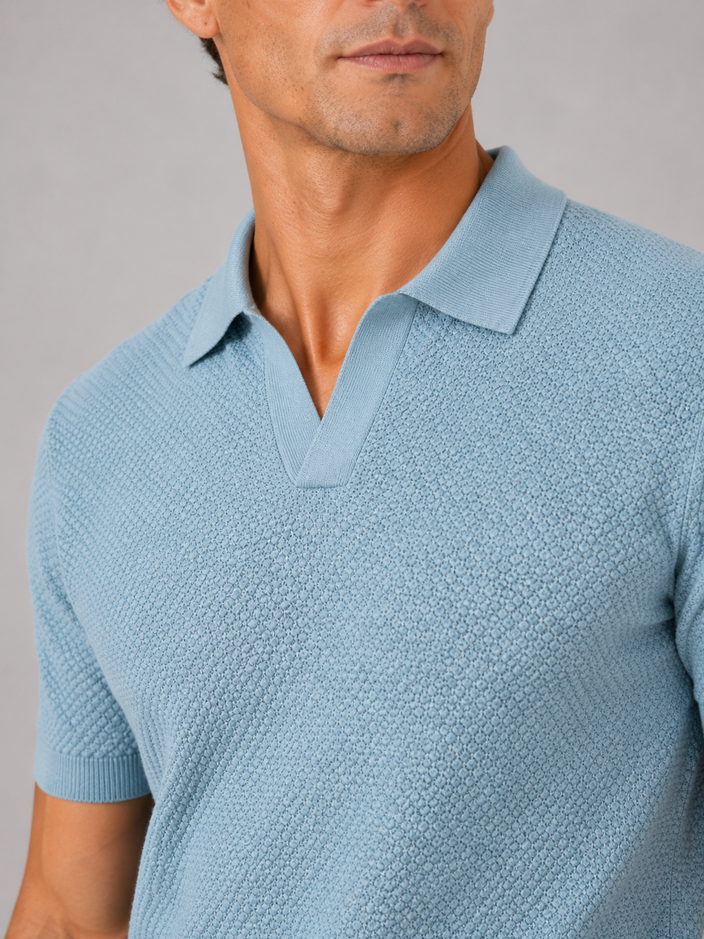 Close up of light blue knit polo showing soft breathable stretch fabric and refined collar detail