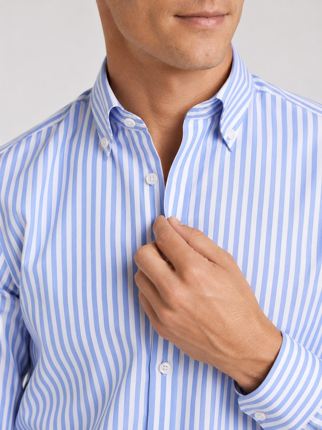 Close up of light blue striped dress shirt showing crisp fabric and refined collar detail