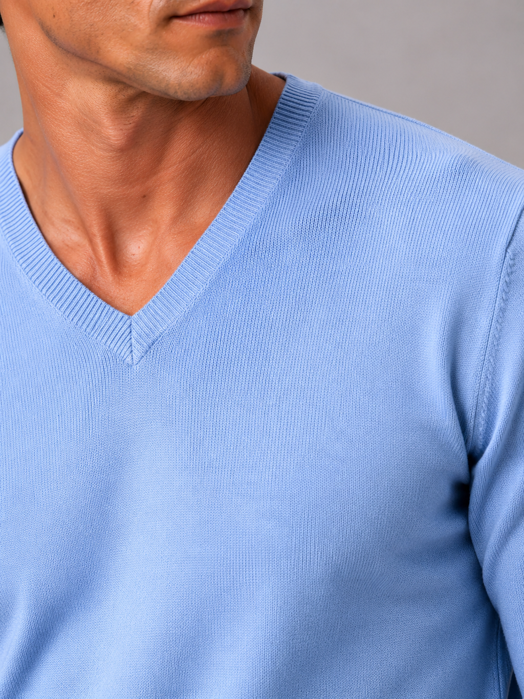 Close up of light blue knit sweater showing soft lightweight fabric and refined v neck detail
