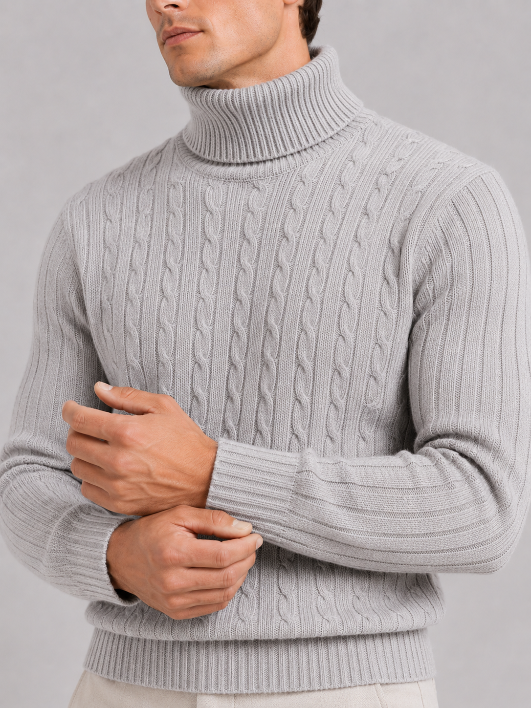 Close up of light gray cable knit turtleneck showing thick textured fabric and warm collar detail