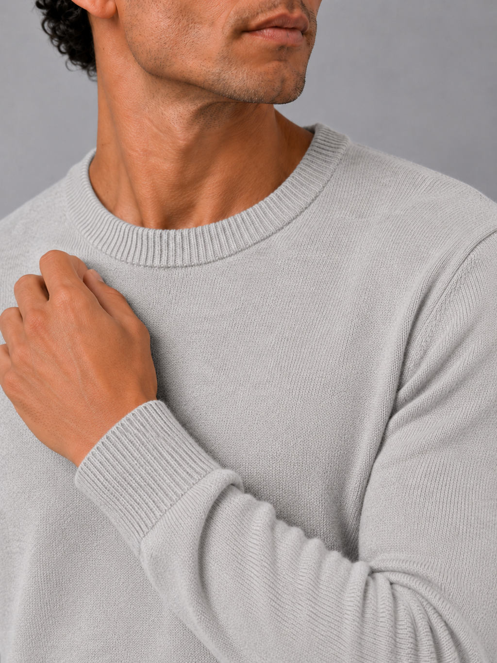 Close up of light gray knit sweater showing soft lightweight fabric and clean crew neck detail