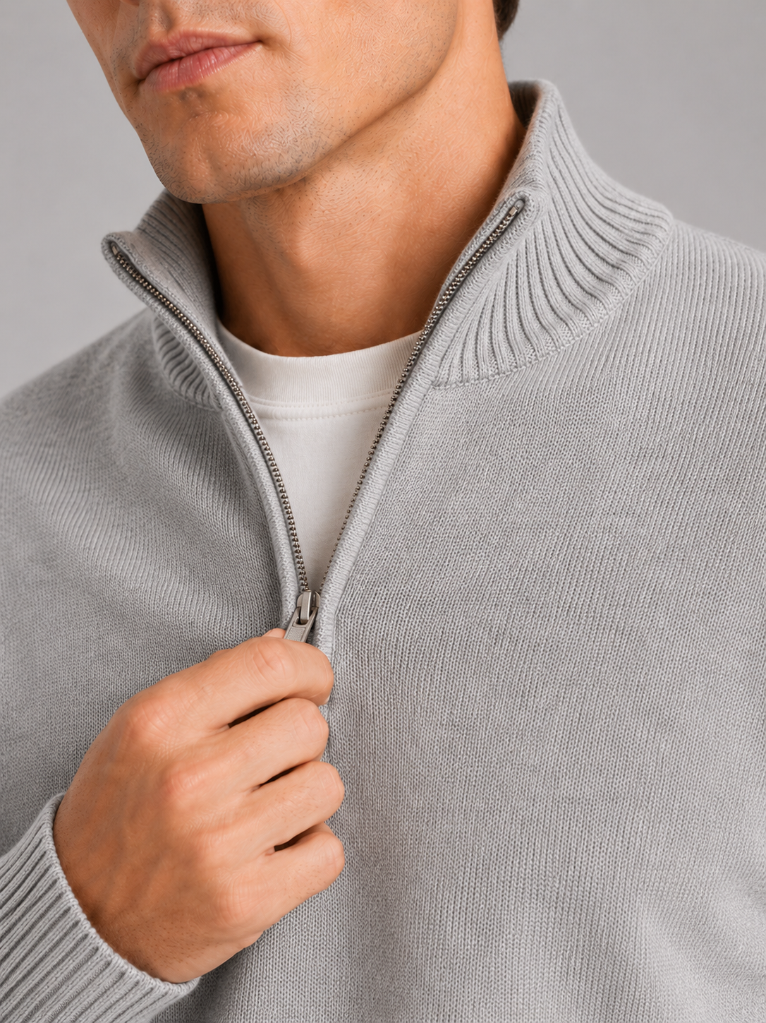 Close up of light gray half zip sweater showing soft knit texture and refined zipper detail