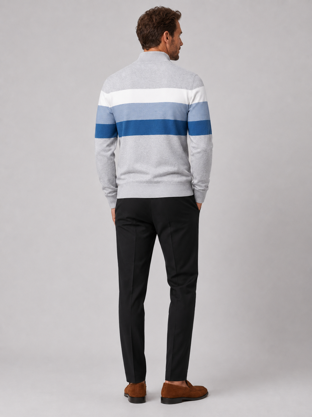 Back view of a man wearing a light gray cotton quarter zip sweater showing the patchwork design and relaxed fit