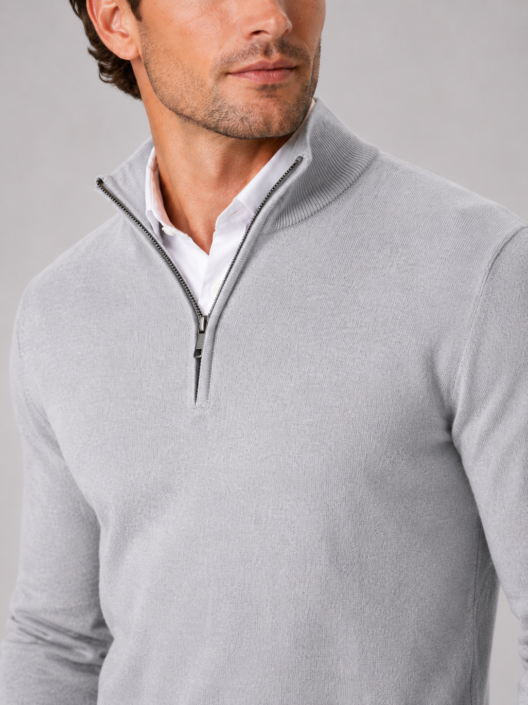 Close up of light gray quarter zip sweater showing soft knit texture and mock neck zipper detail