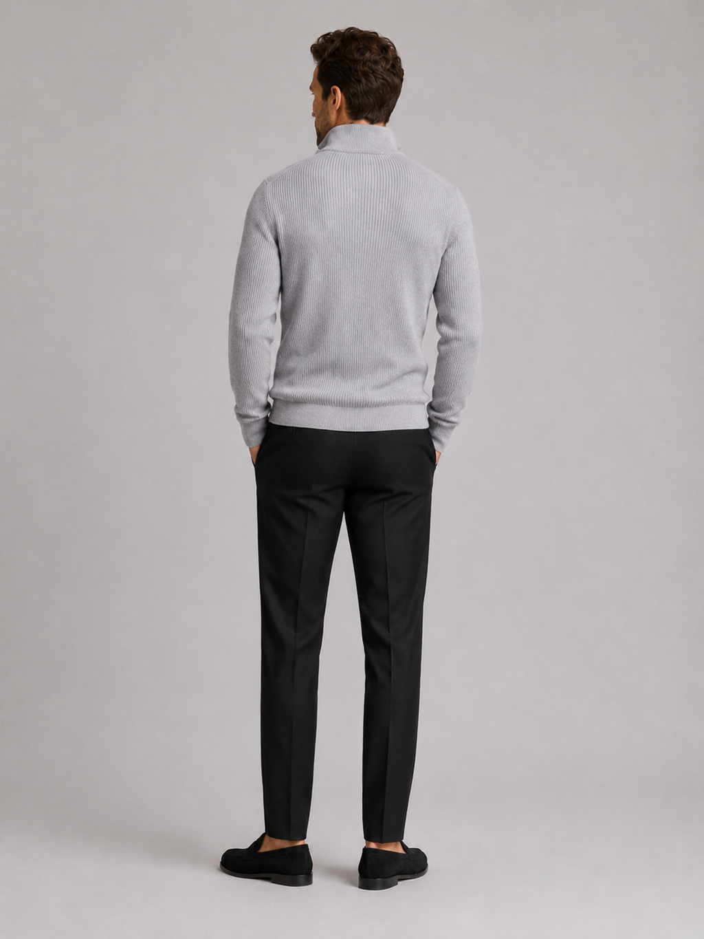 Back view of a man wearing a light gray quarter zip sweater showing the slim fit, long sleeves, and clean knit finish