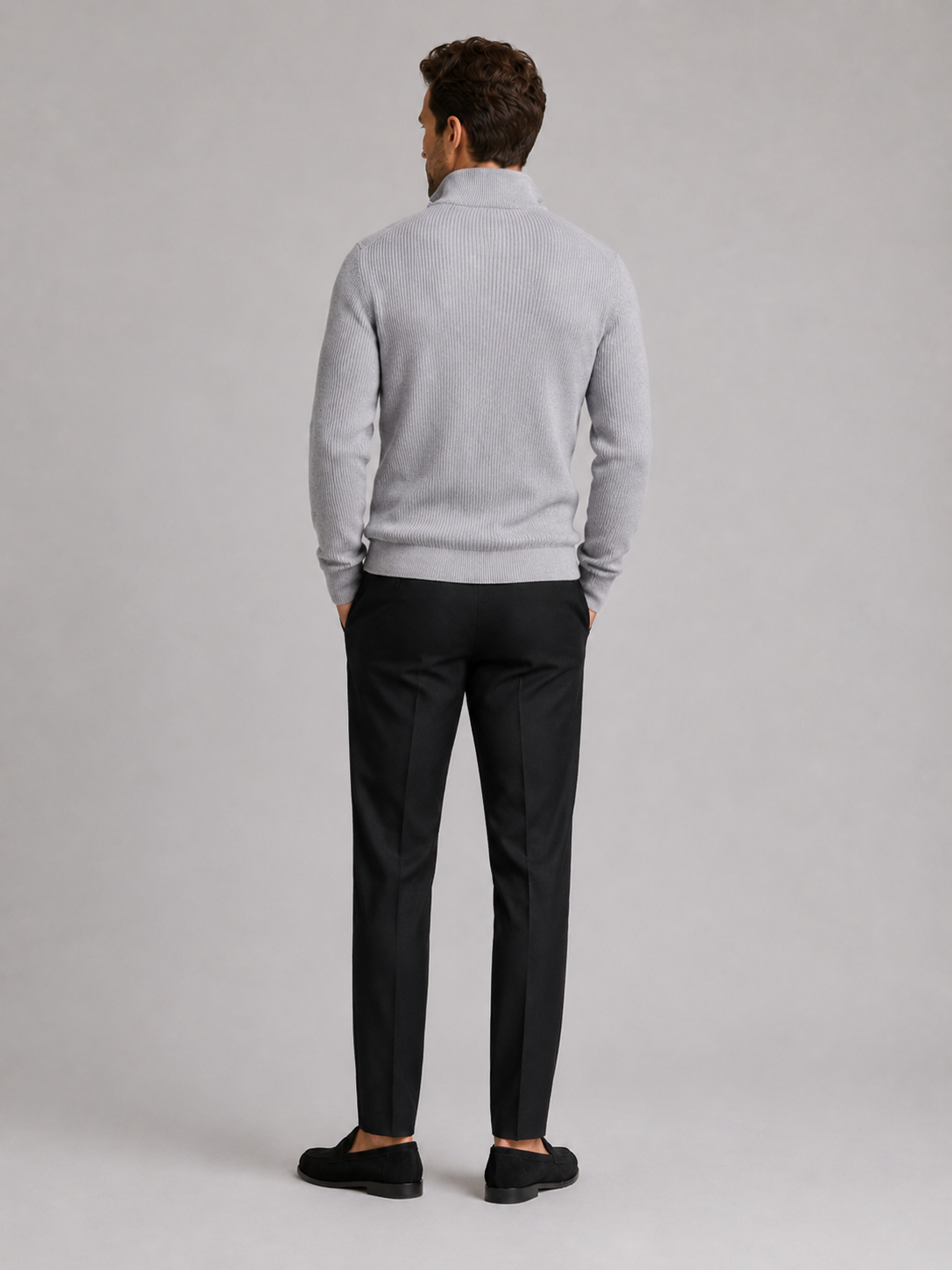 Back view of a man wearing a light gray quarter zip sweater showing the slim fit, long sleeves, and clean knit finish
