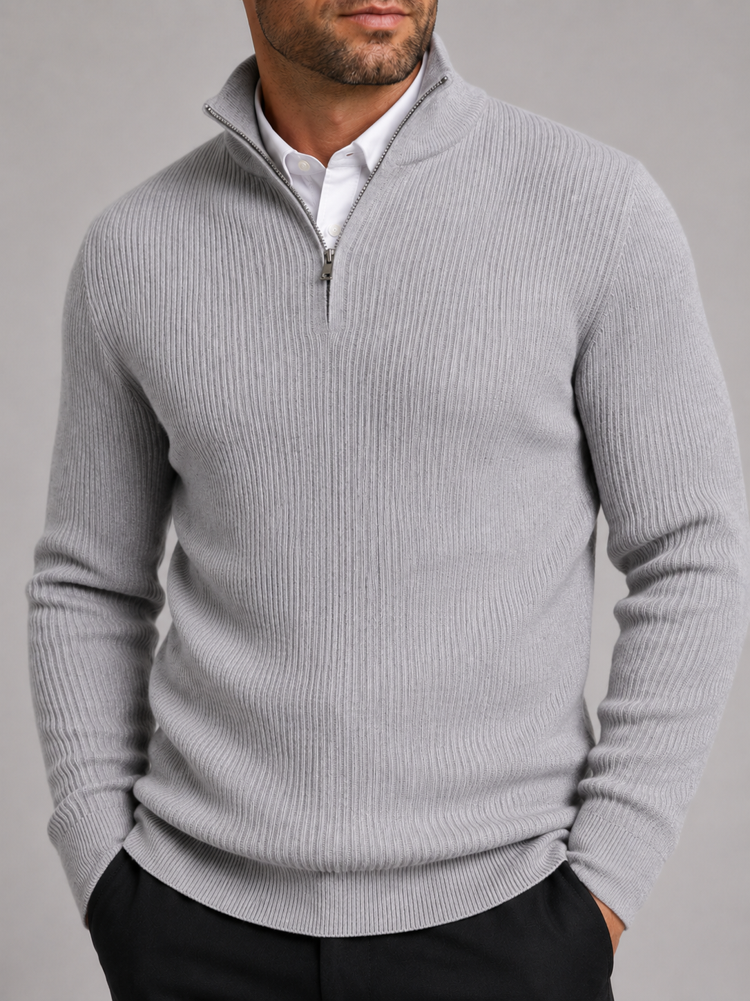 Close-up of a light gray quarter zip sweater showing the warm knit texture, mock neck, zipper, cuffs, and stitching