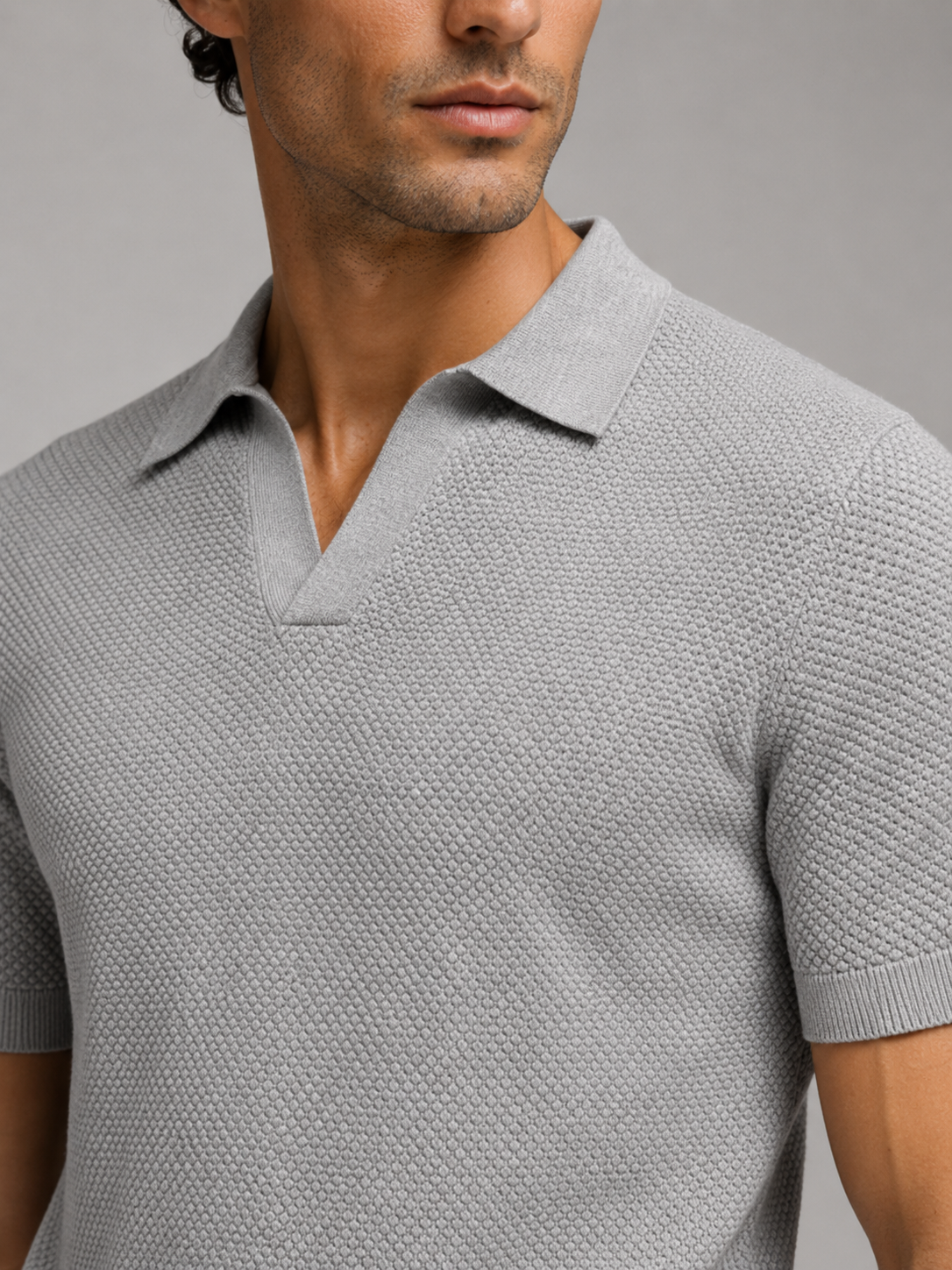 Close up of light gray knit polo showing soft breathable stretch fabric and refined collar detail