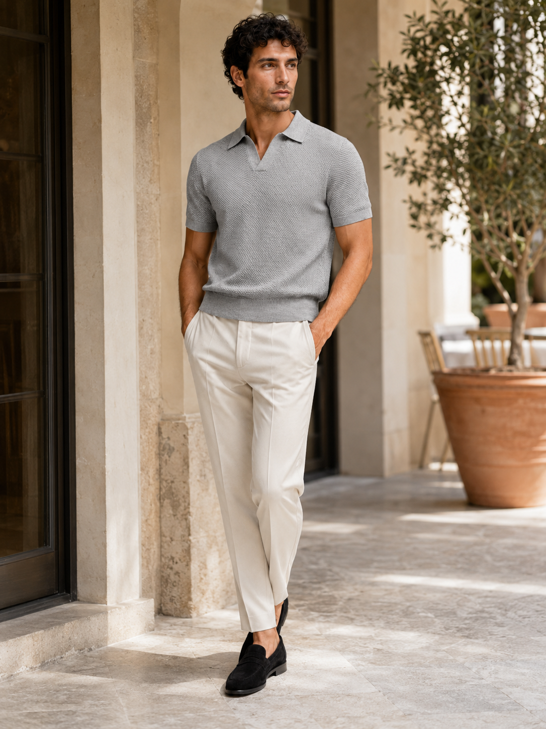 Man styling light gray knit polo shirt in a clean summer lifestyle outfit