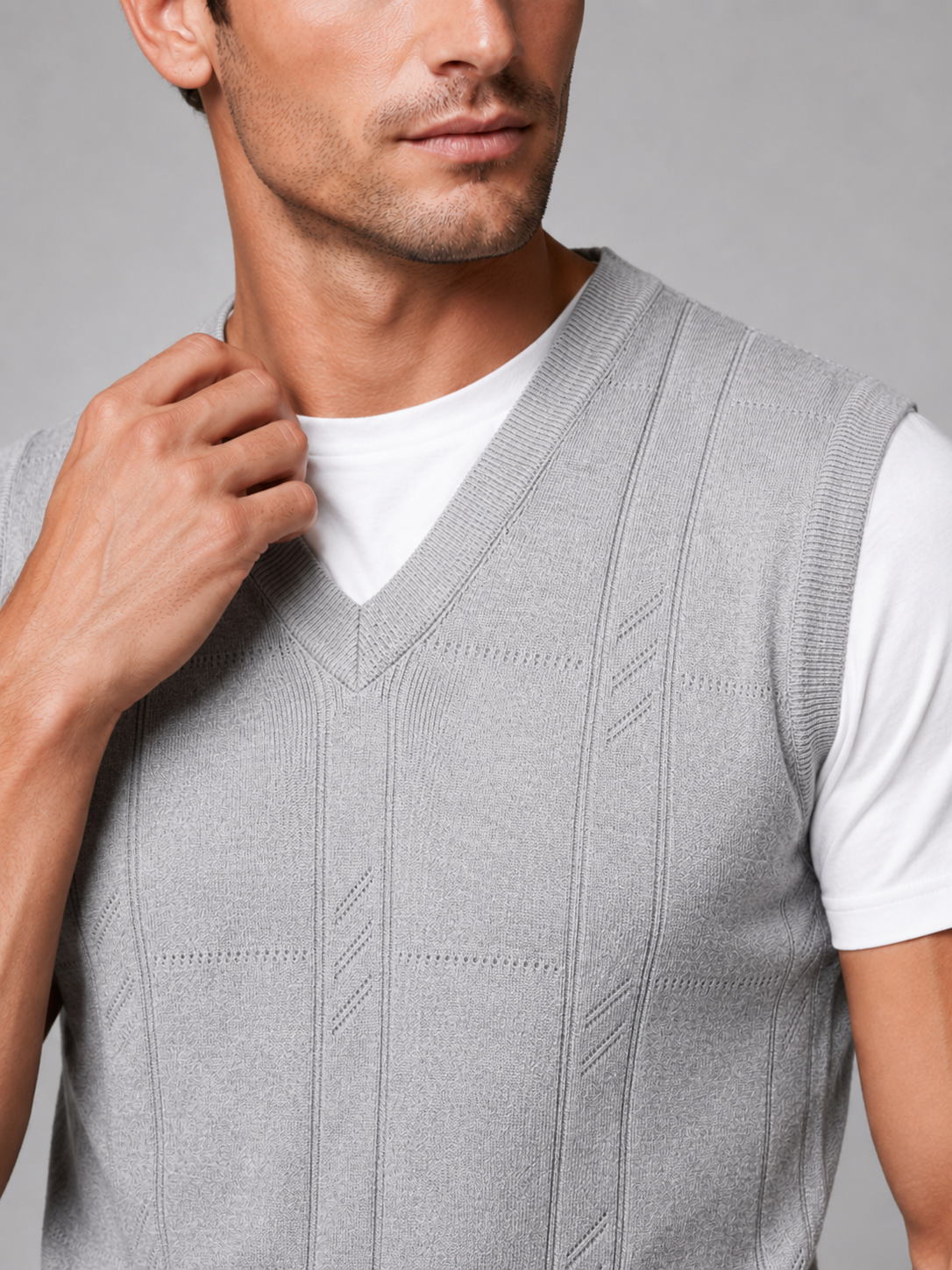 Close up of light gray sweater vest showing soft knit texture and classic v neck detail