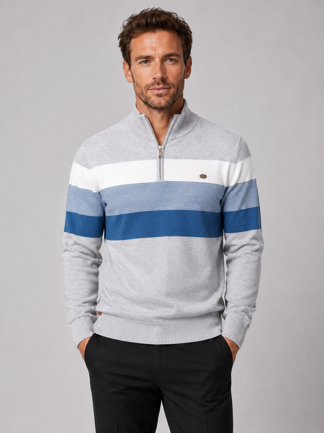 Front view of a man wearing a light gray patchwork cotton quarter zip sweater with a mock neck and long sleeves