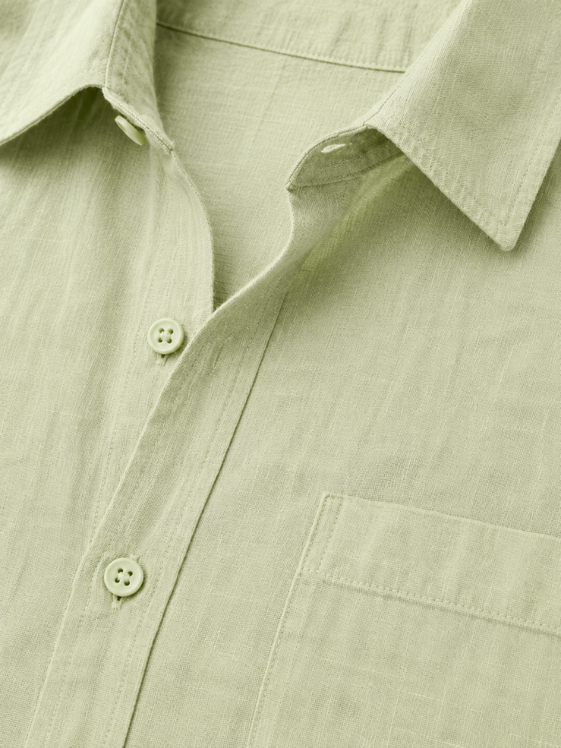 Close up of mint green linen shirt fabric showing soft breathable natural woven texture