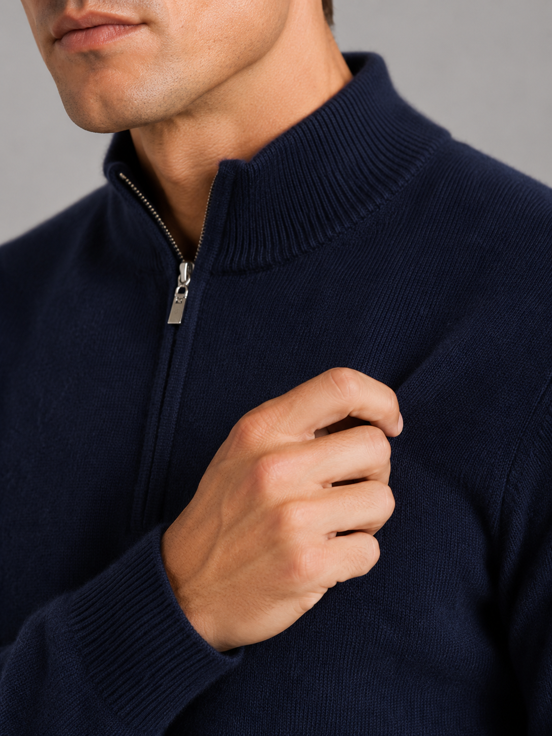 Close up of navy wool half zip sweater showing thick knit texture and refined zipper detail