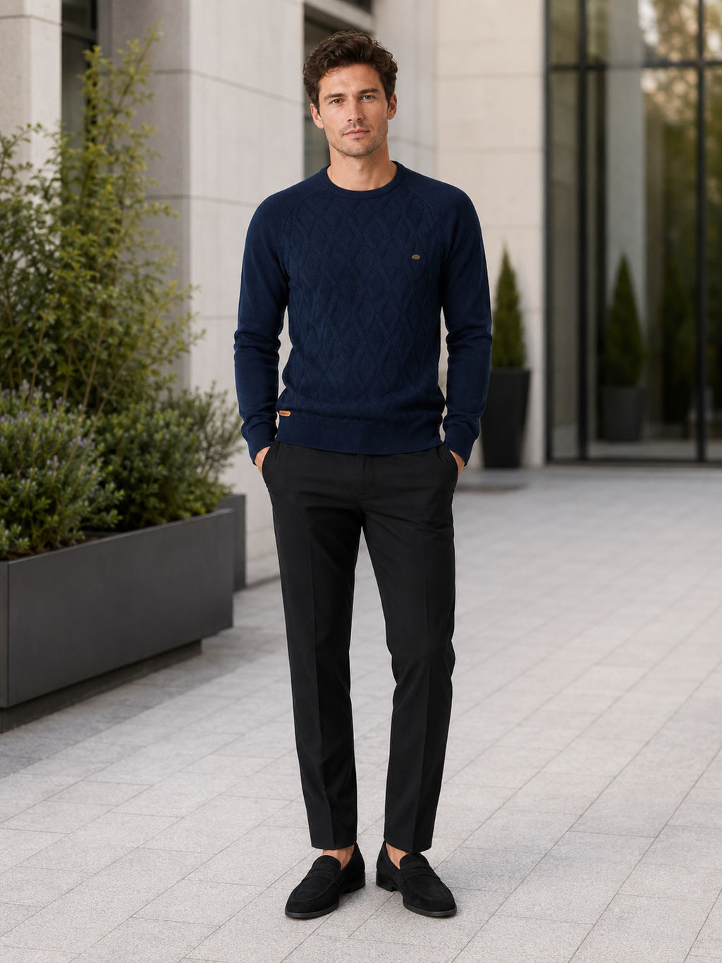 Man wearing a navy argyle crew neck sweater in a classic business casual winter outfit