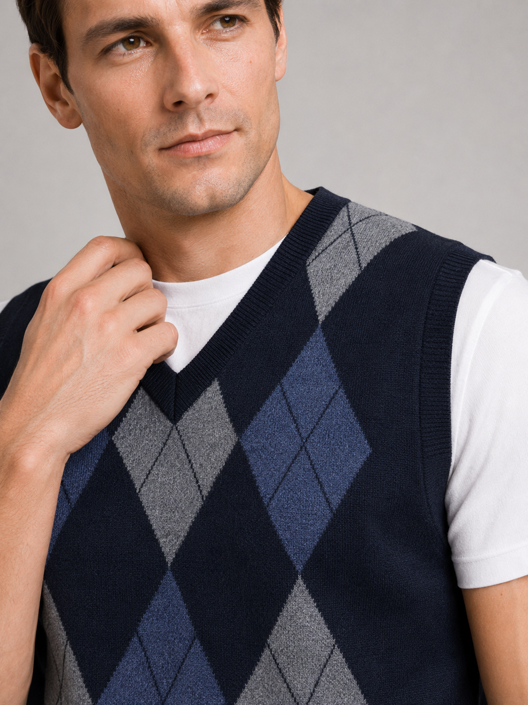 Close up of navy argyle sweater vest showing classic diamond knit pattern and refined v neck detail
