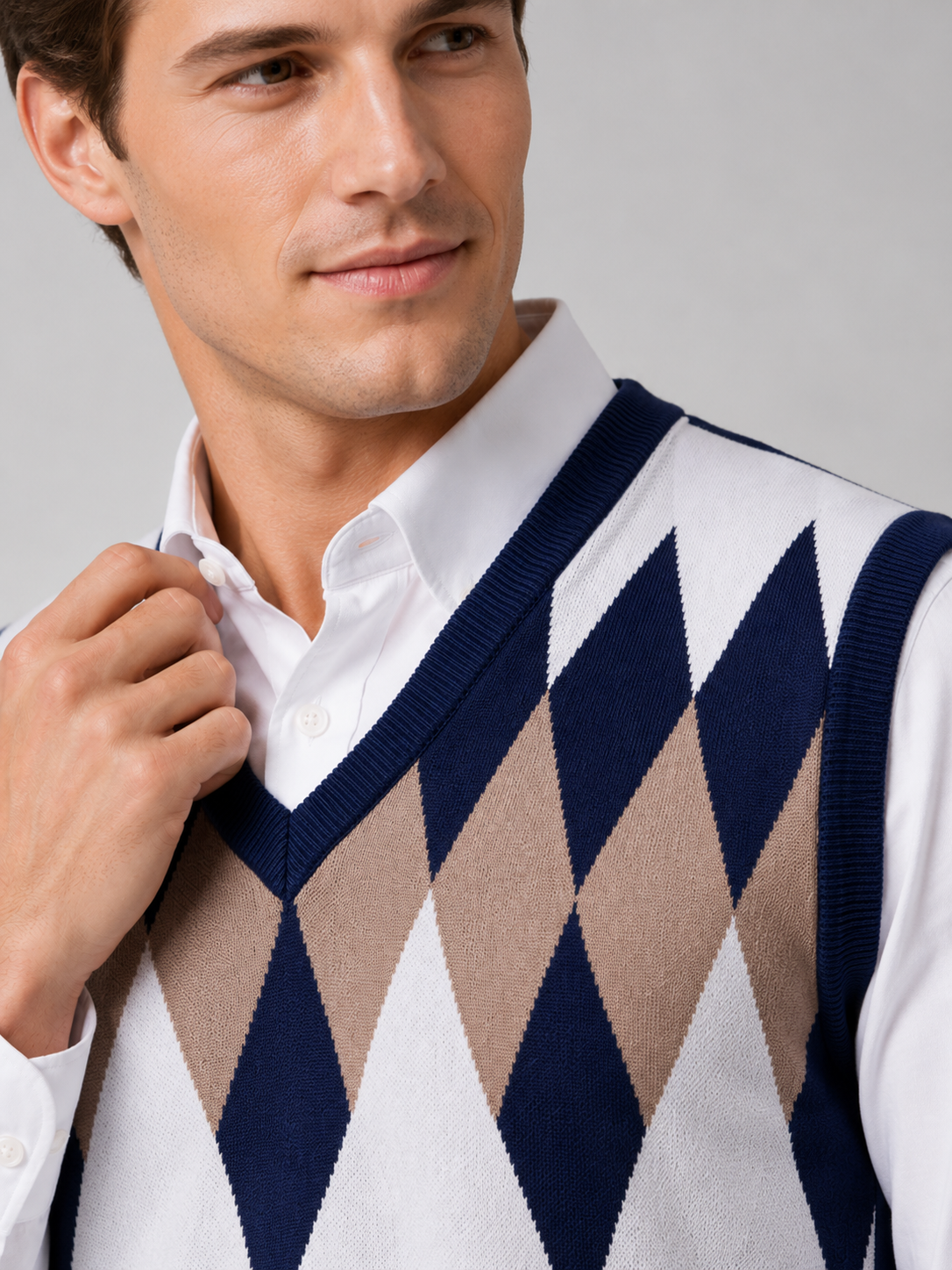Close up of navy argyle sweater vest showing classic diamond knit pattern and refined v neck detail