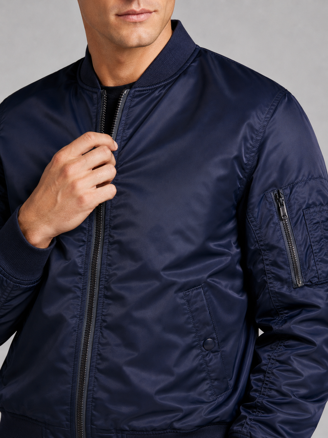 Close up of navy bomber jacket showing lightweight windbreaker fabric and zip up front detail