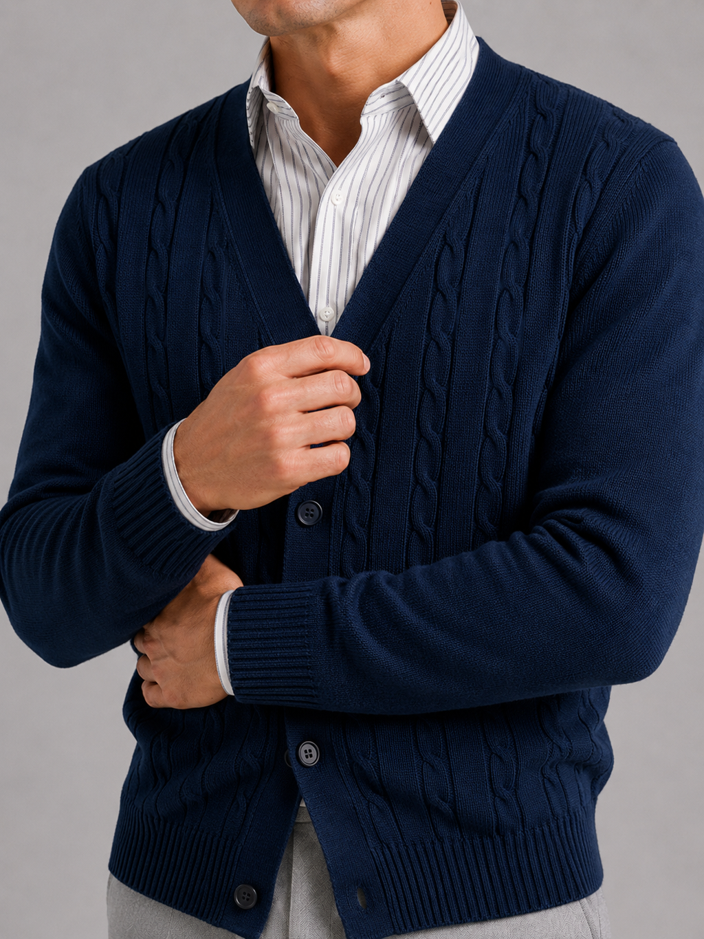 Close up of navy cable knit cardigan showing soft textured fabric and button front detail