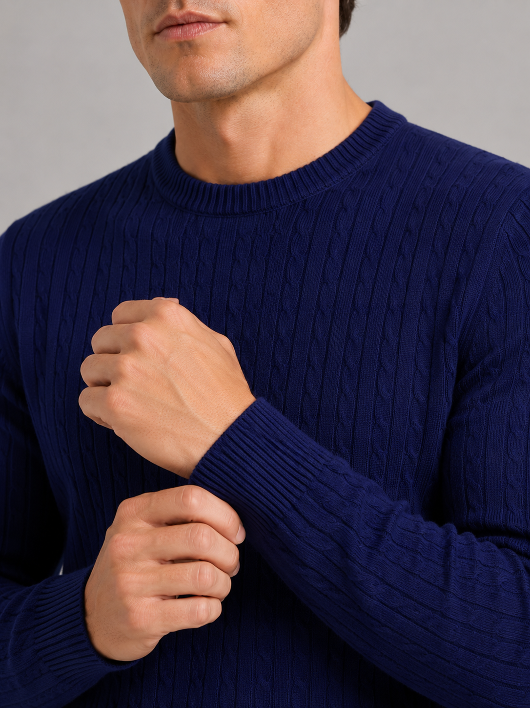 Close up of navy cable knit sweater showing soft textured fabric and clean crew neck detail