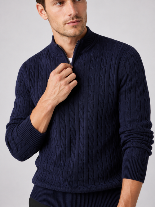 Close up of navy cable knit sweater showing textured pattern, mock neck, and quarter zip detail