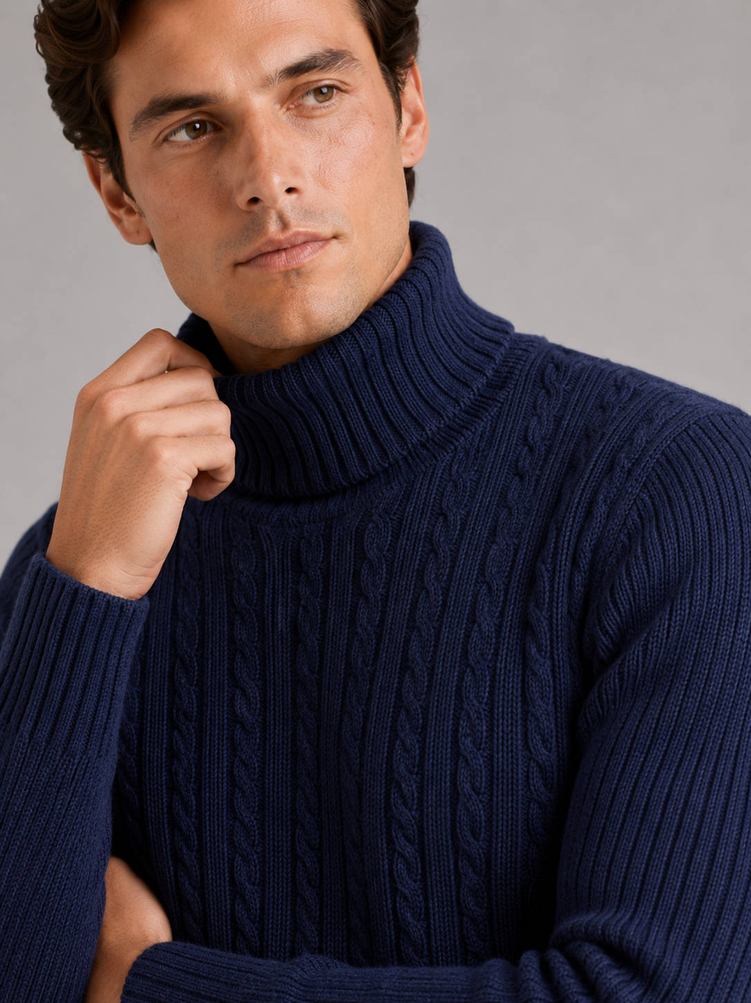 Close up of navy cable knit turtleneck showing thick textured fabric and warm collar detail