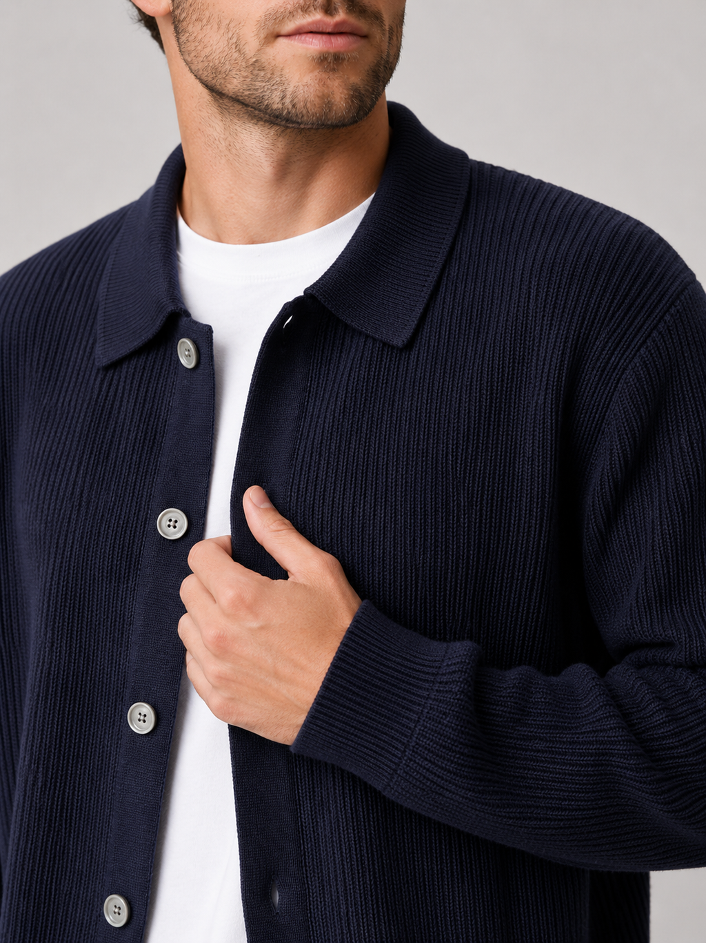 Close up of navy knit cardigan showing soft textured fabric and relaxed lapel collar detail