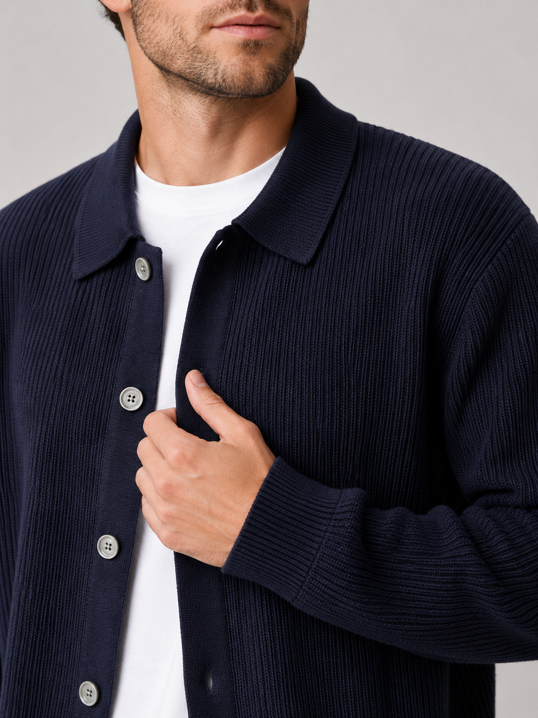 Close up of navy knit cardigan showing soft textured fabric and relaxed lapel collar detail