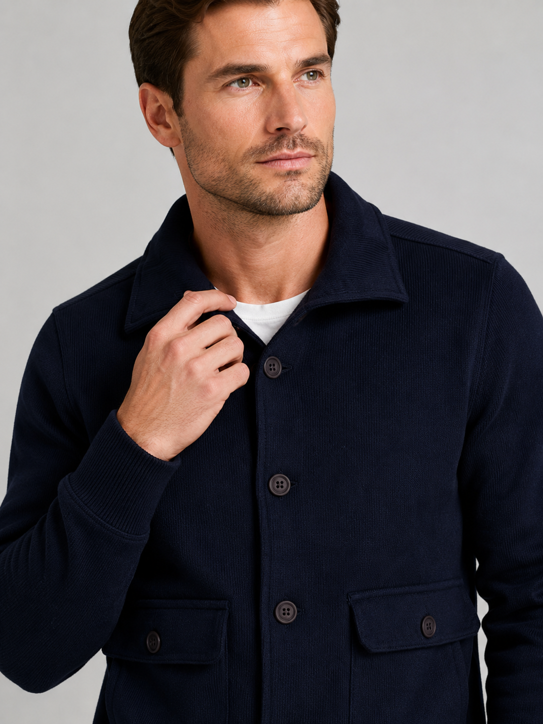Close up of navy chore jacket showing durable fabric, button up front, and utility pocket detail