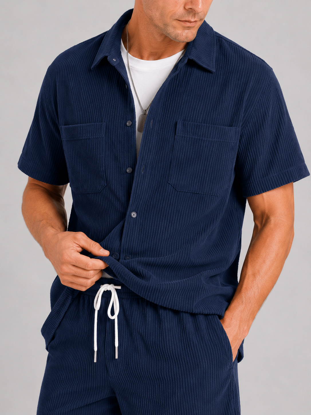 Close up of navy corduroy two piece set showing soft textured fabric and button up shirt detail