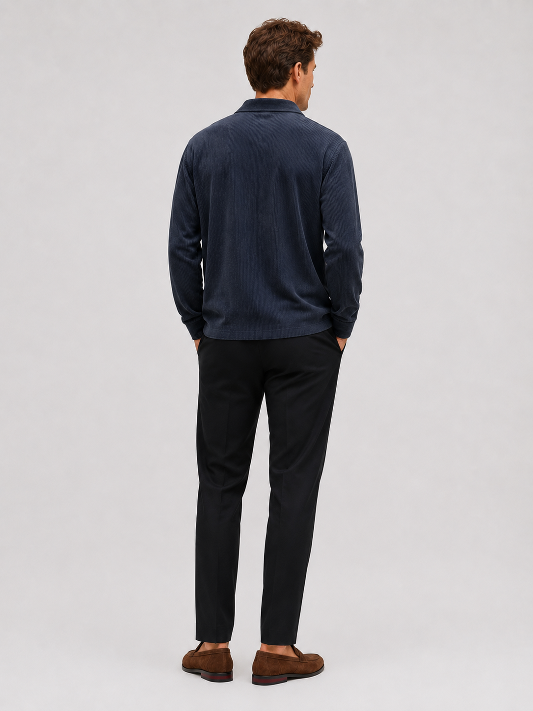 Close-up of a navy corduroy polo shirt showing the textured polyester fabric, contrast turn-down collar, button placket, cuffs, and stitching
